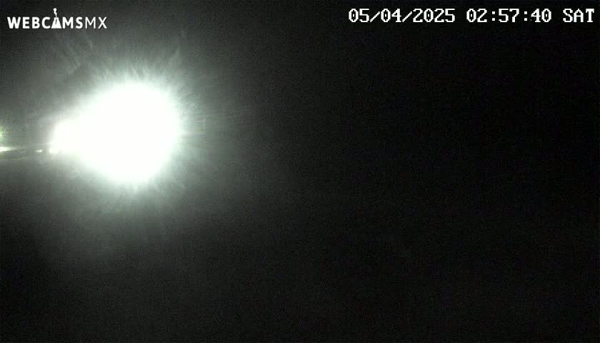 A bright light source dominates a dark, nighttime scene.