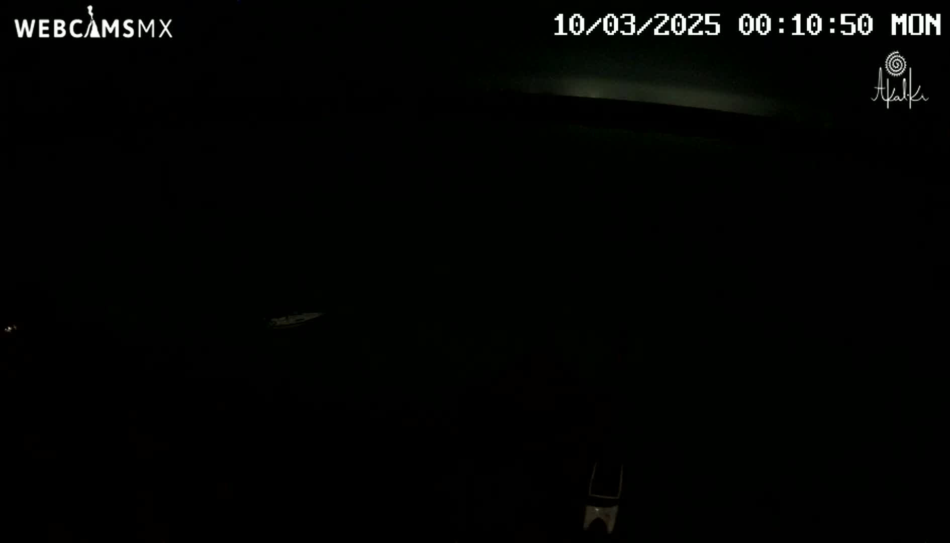 A mostly dark image shows a small, indistinct object in the distance, possibly at night.