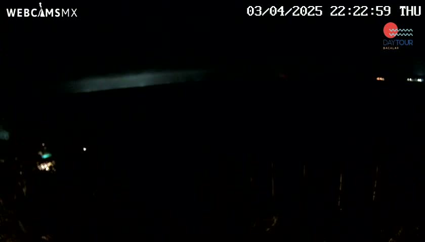 A nighttime, dark outdoor scene shows a faint, bright horizontal line in the distance.