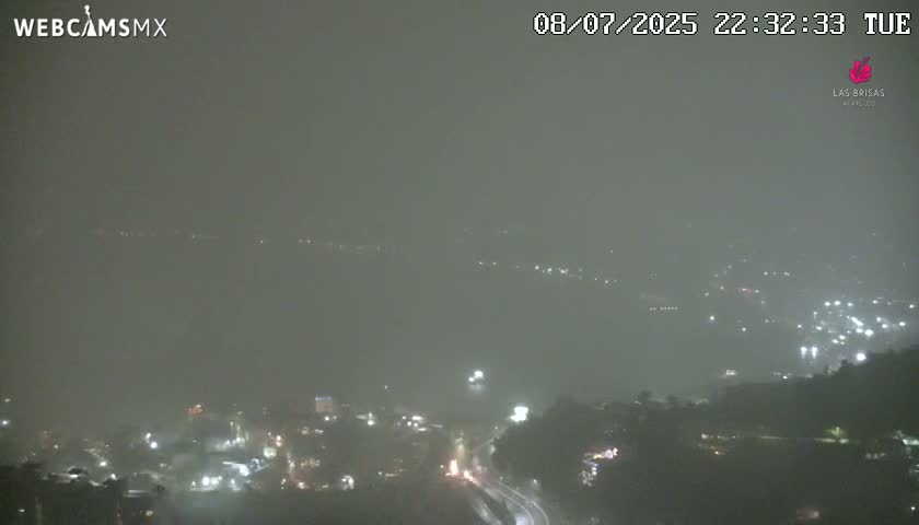 A nighttime, hazy view of a city partially obscured by fog or mist.