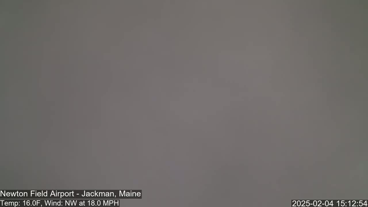 A uniformly gray, overcast sky is visible, with a northwest wind blowing at 18 mph.