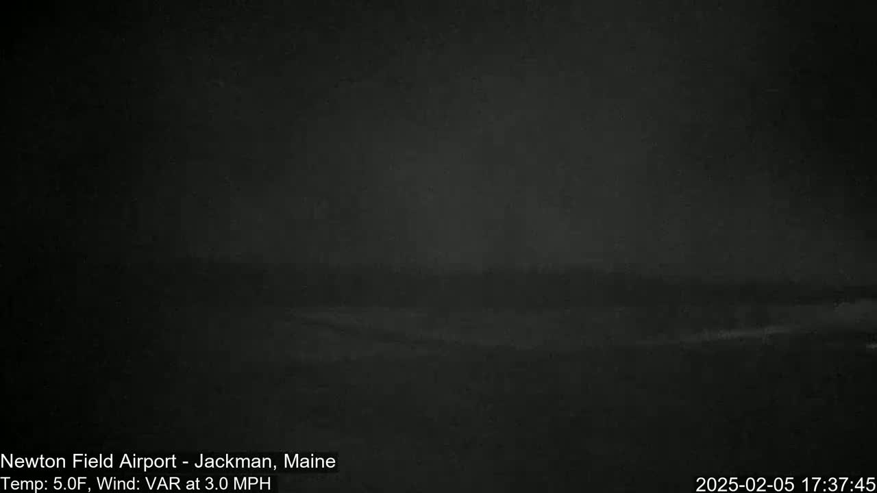 A dark, nighttime outdoor scene shows a blurry, indistinct landscape under a dark sky.
