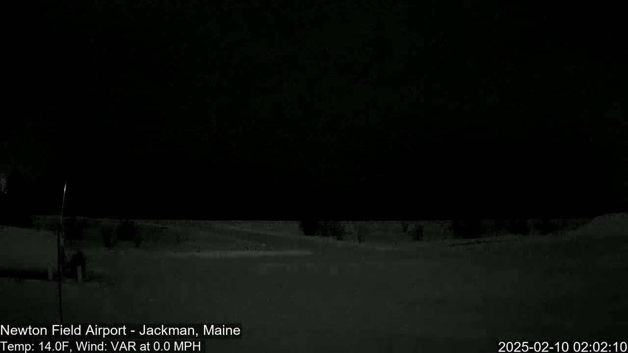 A nighttime, snow-covered landscape is visible under a dark sky, with calm, nearly windless conditions.
