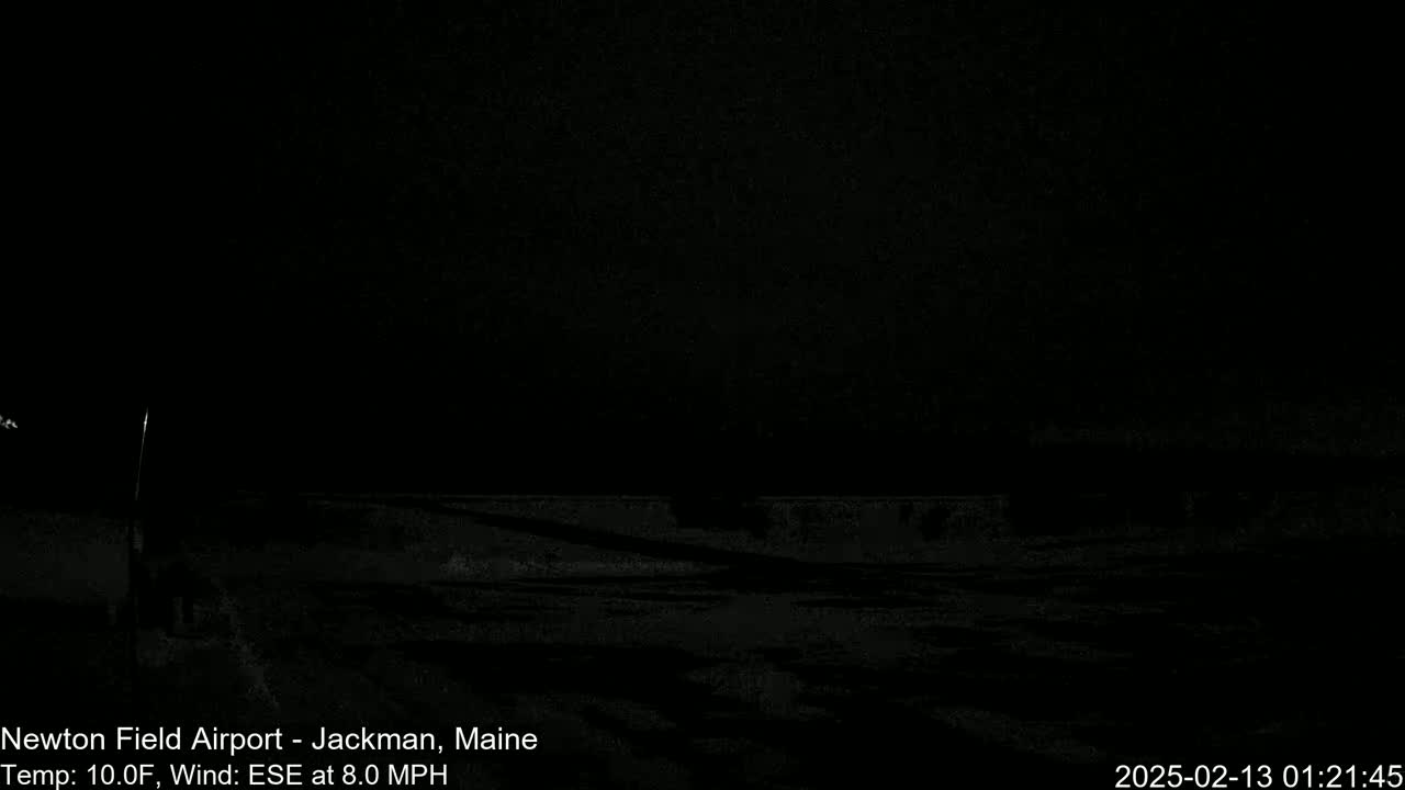 A dark, nighttime outdoor scene shows a flat, snow-covered ground under a black sky with a wind of 8 mph from the east-southeast and a temperature of 10°F.