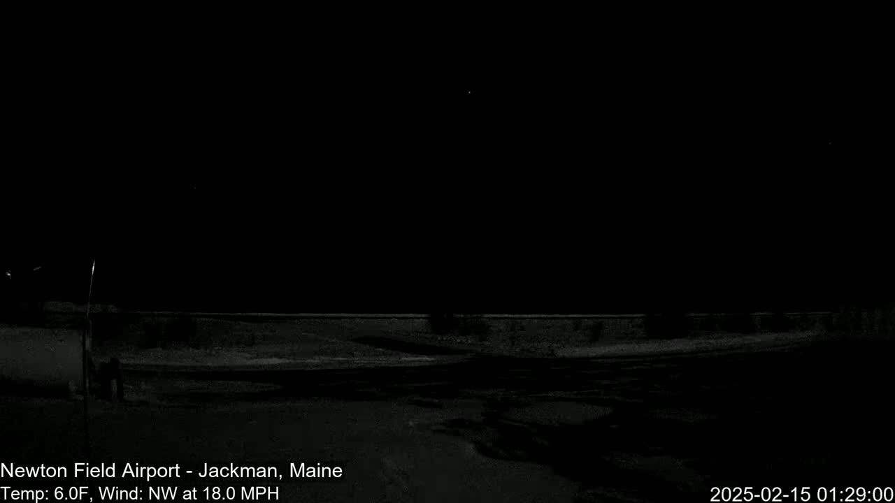 A dark, nighttime scene of a snow-covered area with a low wall under a clear, starlit sky, with a northwest wind at 18 mph and a temperature of 6 degrees Fahrenheit.
