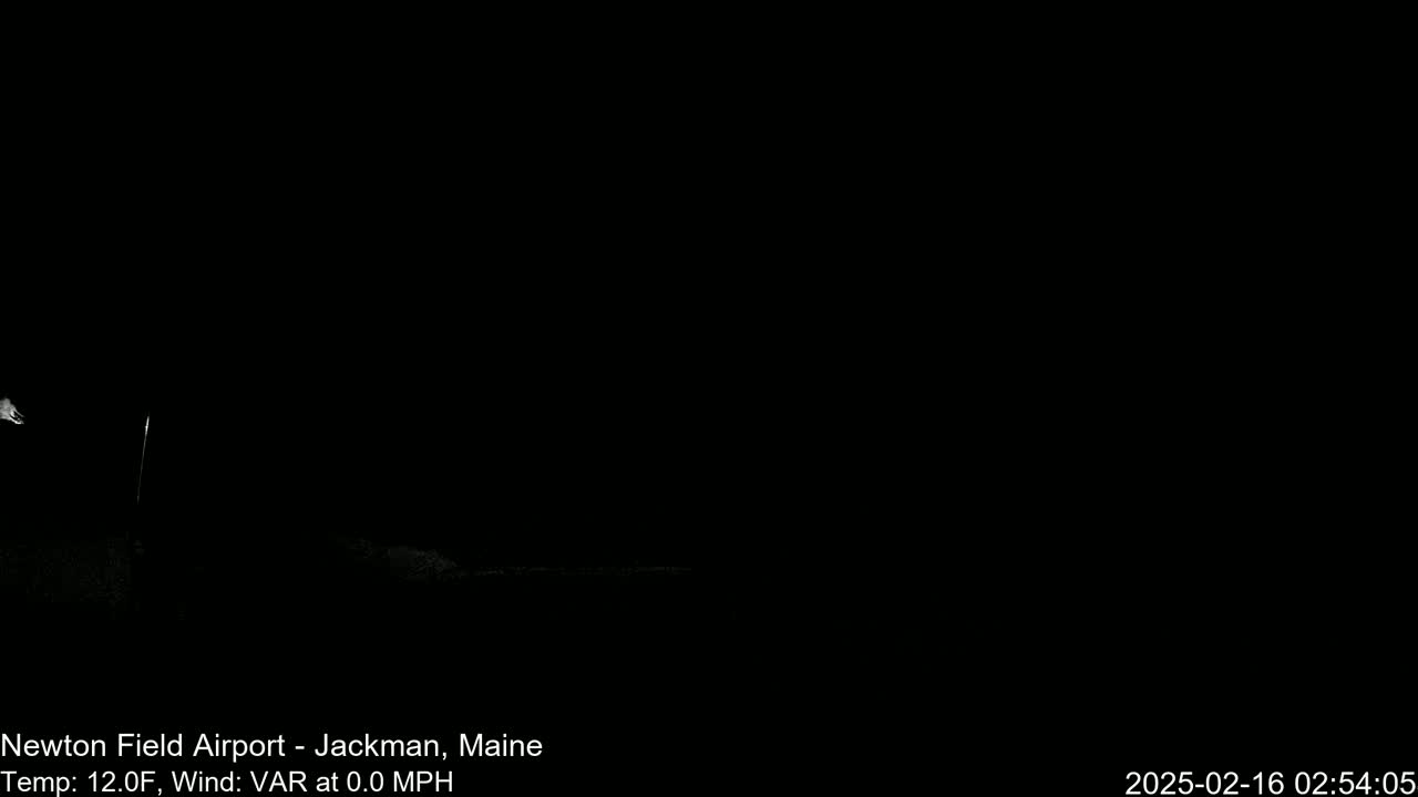 A nighttime, outdoor scene shows a dark expanse with a faint, white glow near the bottom left, under a dark sky with a 12-degree Fahrenheit temperature and no wind.