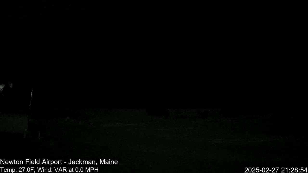 A dark, nighttime scene shows a mostly black ground with a hint of light in the distance.