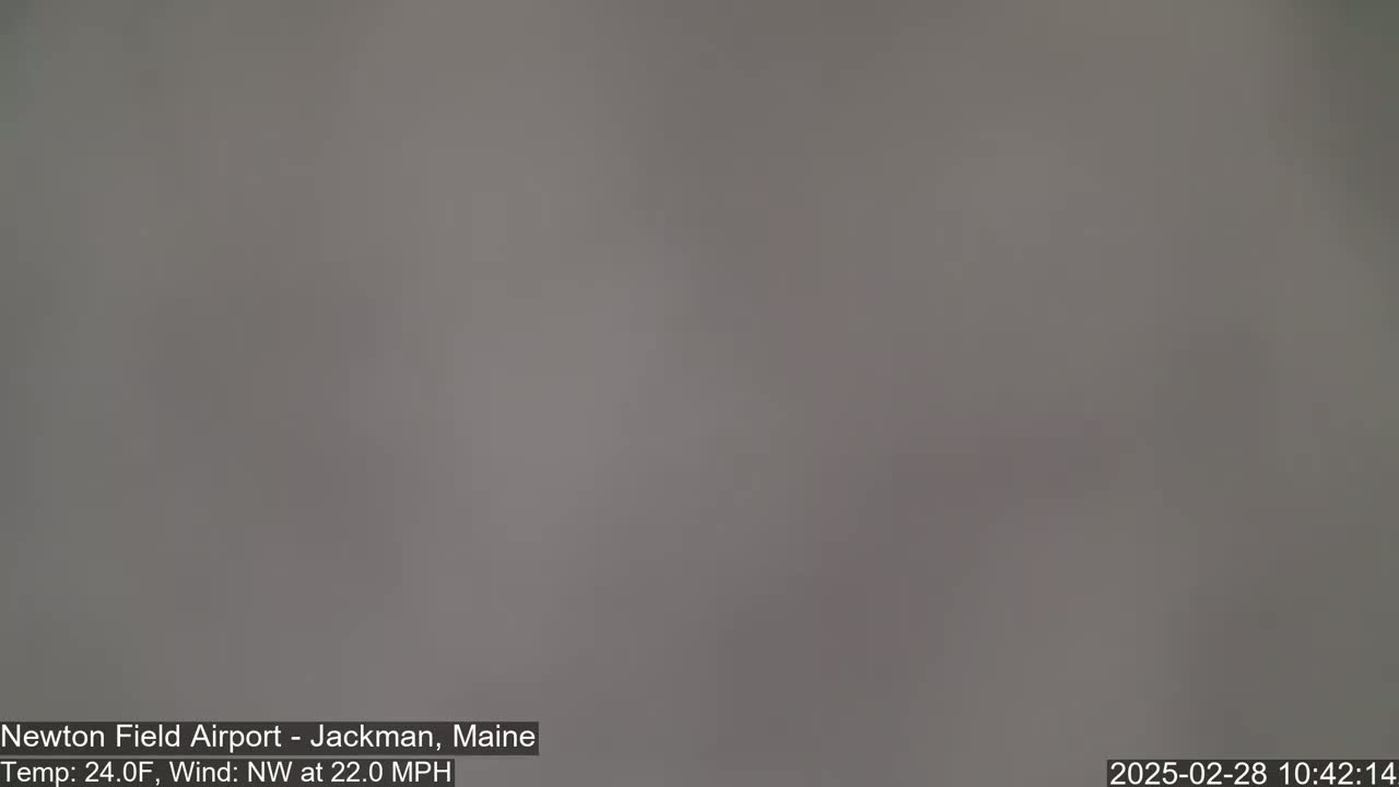 A blurry, gray image shows an overcast sky with a northwest wind of 22 mph and a temperature of 24°F.