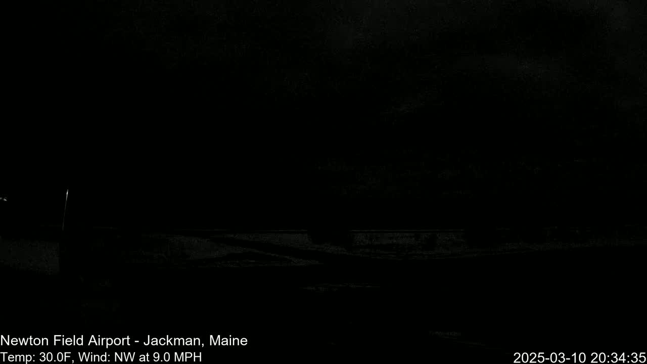 A dark, nighttime scene shows a mostly obscured view of a snowy landscape under a cloudy sky with a northwest wind at 9 mph and a temperature of 30 degrees Fahrenheit.