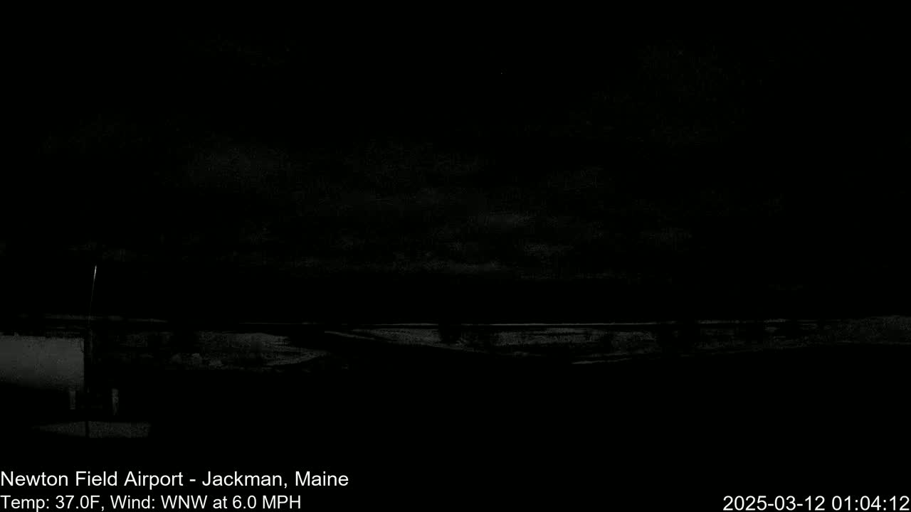 A dark, nighttime view of a snowy, flat landscape under a cloudy sky with a 6.0 mph wind.