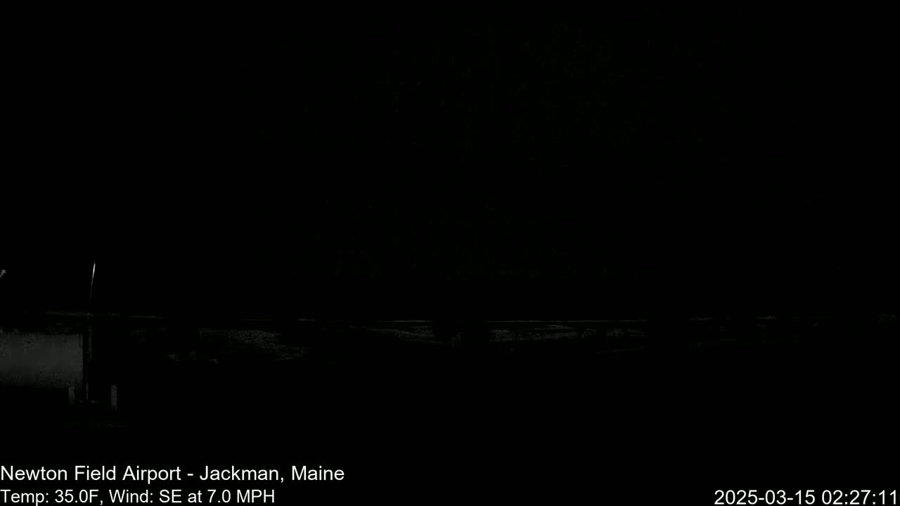 A dark, nighttime outdoor scene shows a flat, snow-covered expanse under a cloudy sky, with a slight southeast wind at 7 mph and a temperature of 35 degrees Fahrenheit.