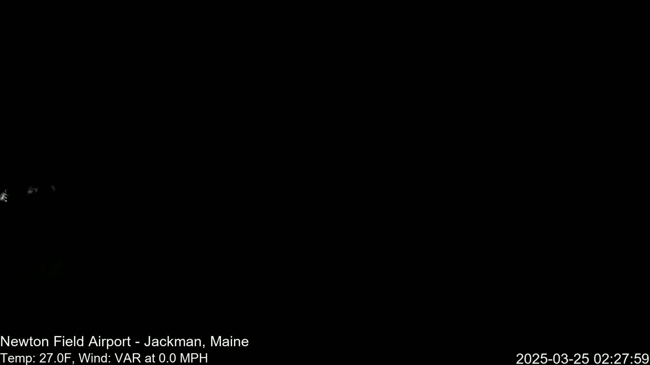 A mostly black image shows a faint, blurry, light-colored area in the bottom left corner under a dark, nighttime sky.