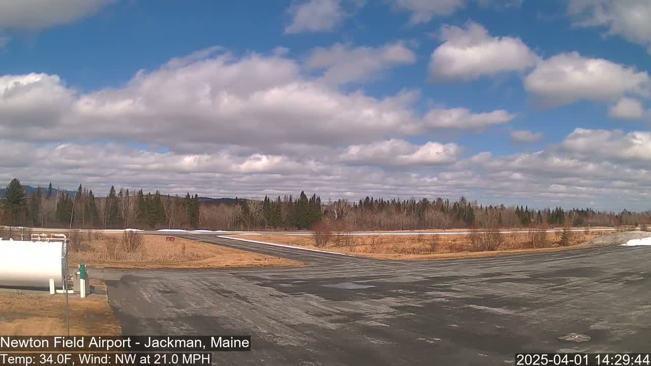 A mostly sunny airfield with a partly cloudy sky and a northwest wind of 21 mph.