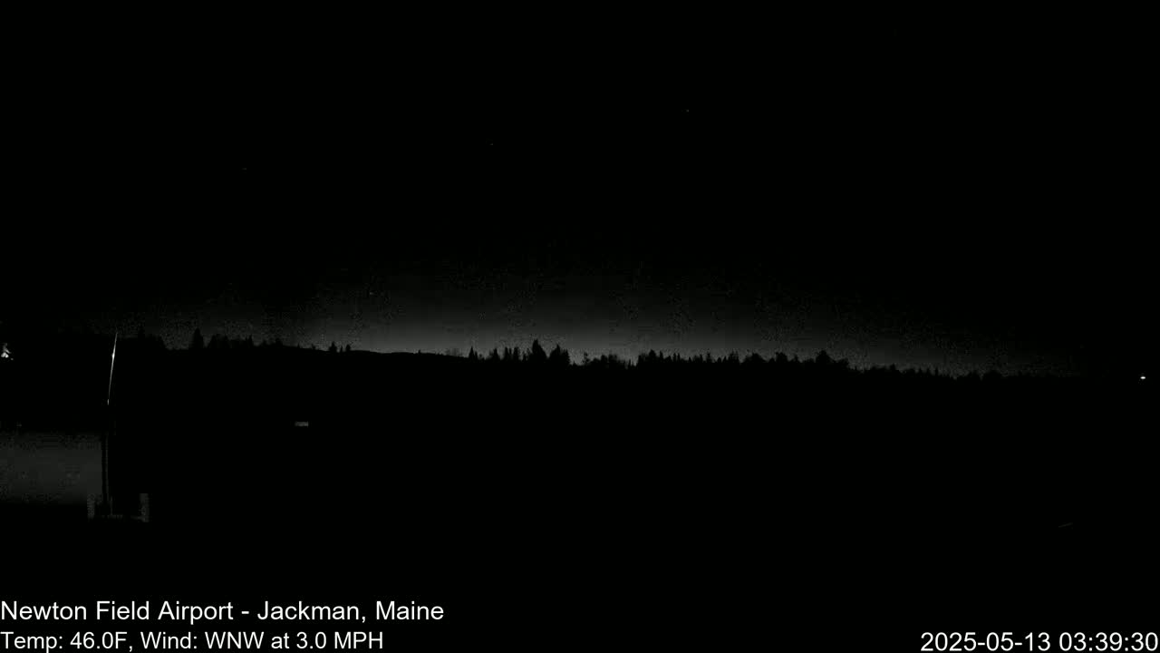 A nighttime, low-light view of a dark treeline under a slightly bright night sky with a 3.0 mph wind from the west-northwest at 46°F.