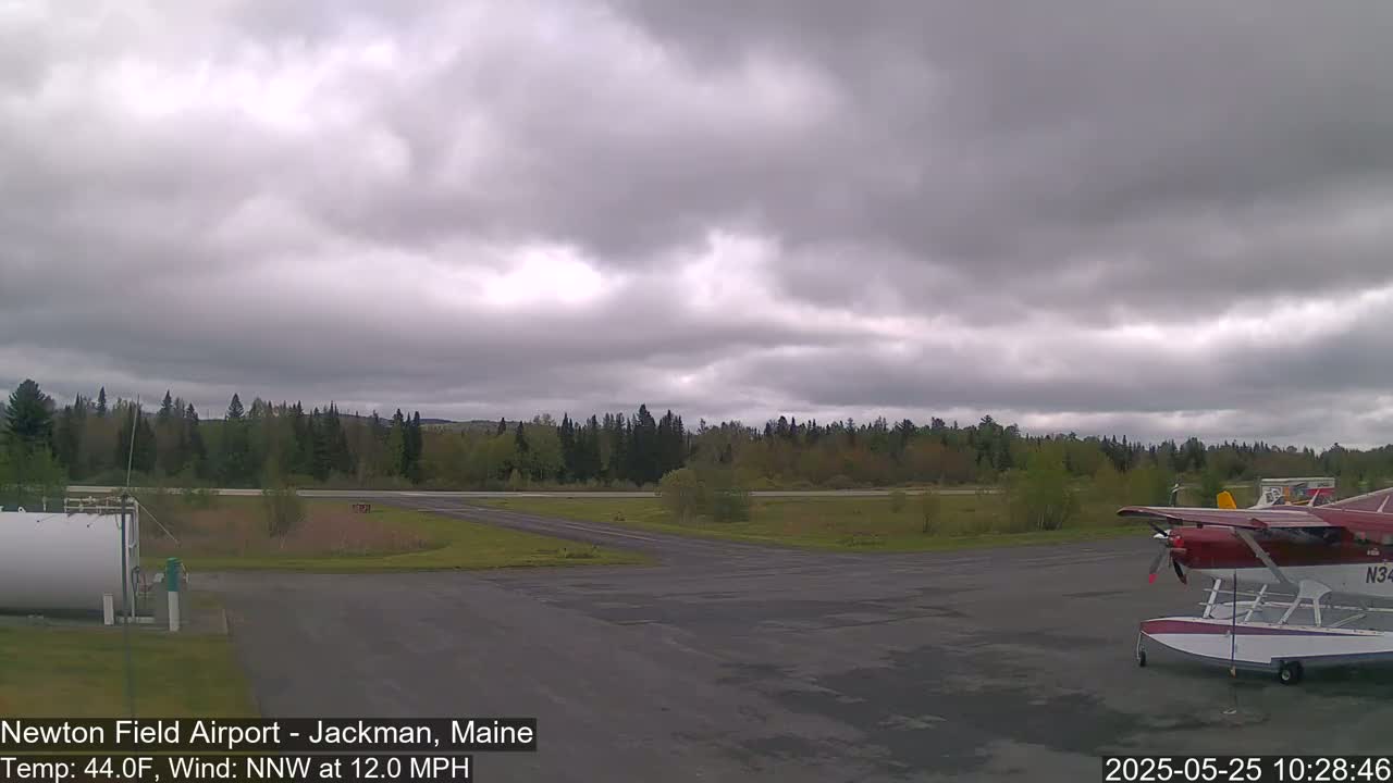 A seaplane sits on the tarmac of an airfield under an overcast sky.