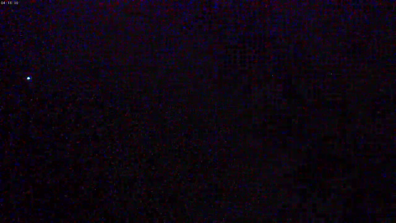 A dark, nighttime scene shows a single, bright light in the distance.