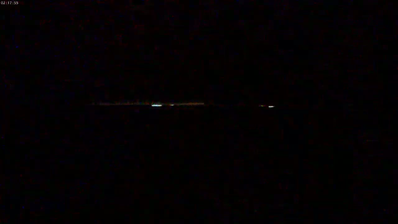 A faint, horizontal line of light is visible against a completely dark, nighttime sky.