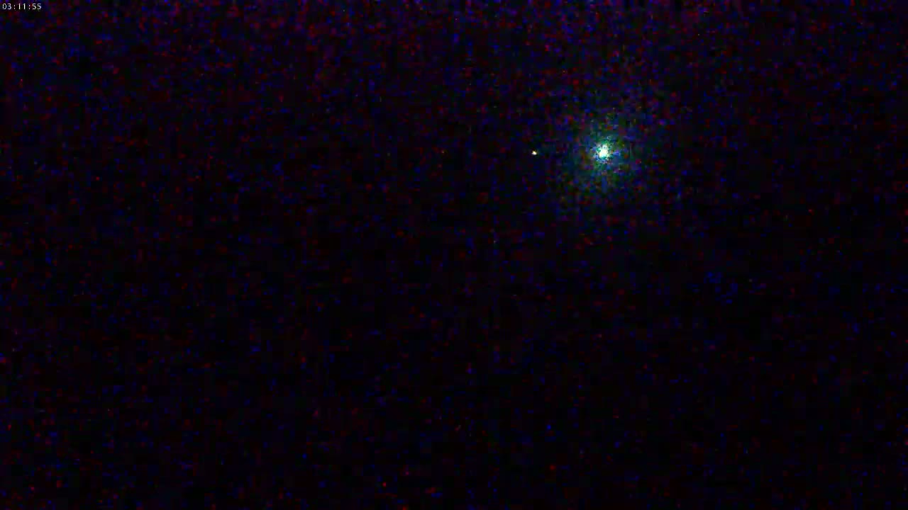 A bright light is visible in a dark, night sky.