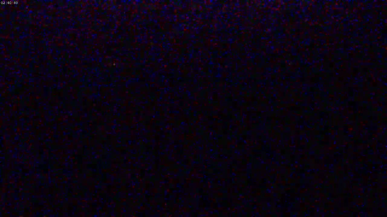The image shows a dark, mostly black screen with scattered specks of blue and red.