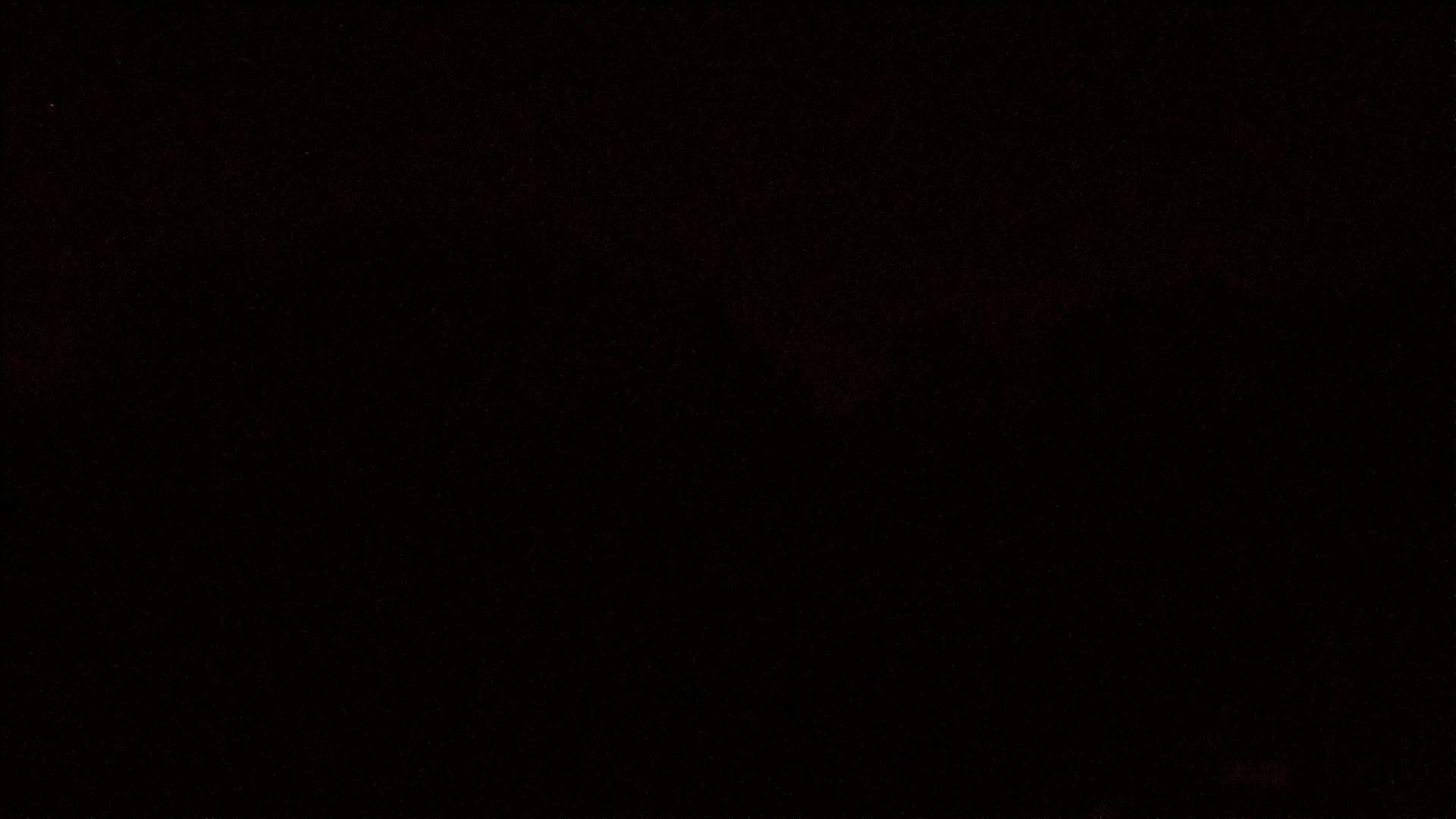 A mostly black image with a few scattered specks of light.