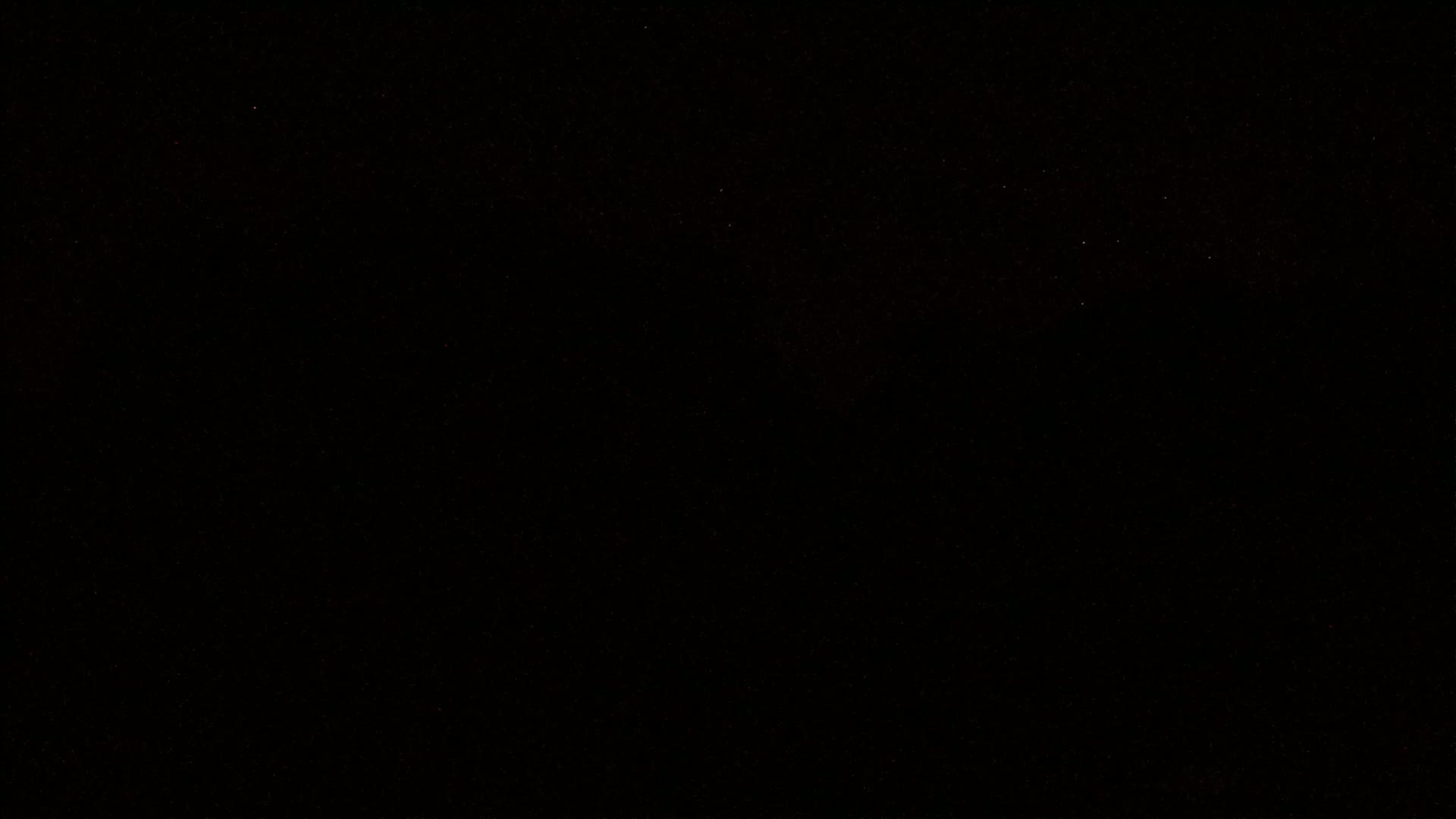 The image shows a completely black field with tiny specs of light scattered throughout.