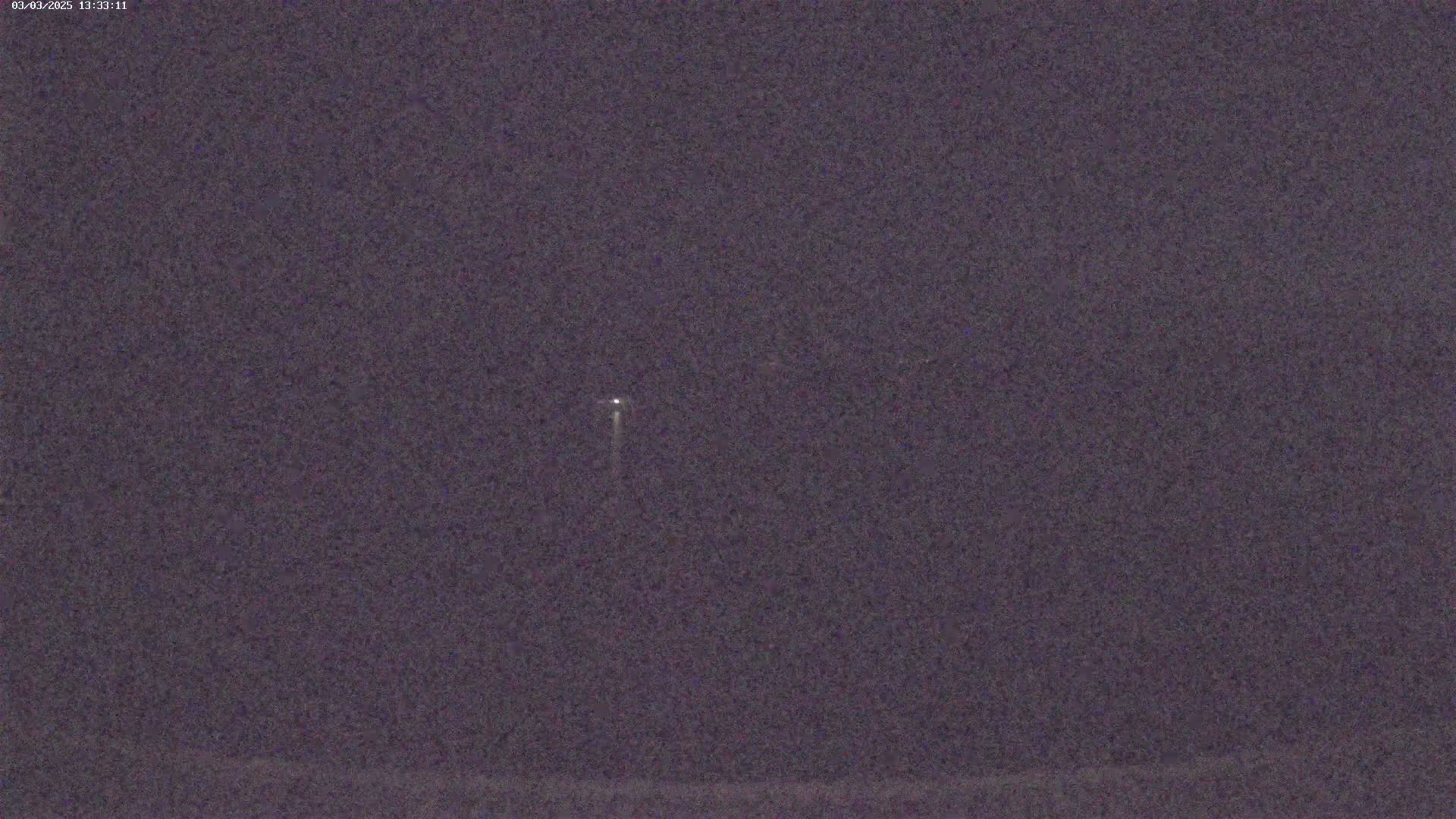 A small, bright light is visible in the night sky.