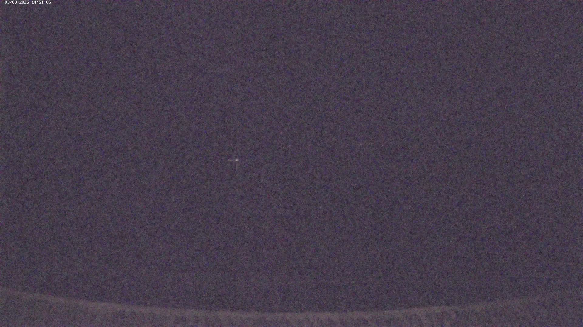 A dark, nighttime sky shows a few faint lights in the distance.