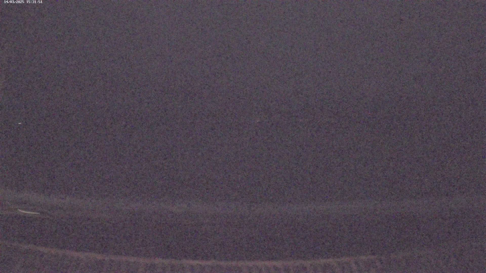 A dark, possibly nighttime, image shows a blurry, indistinct view of a dark landscape.
