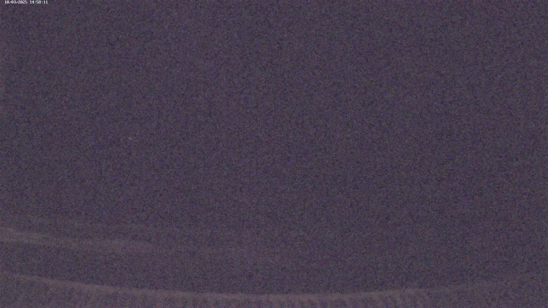 A dark purplish-gray image shows a grainy, textured surface, possibly at night.
