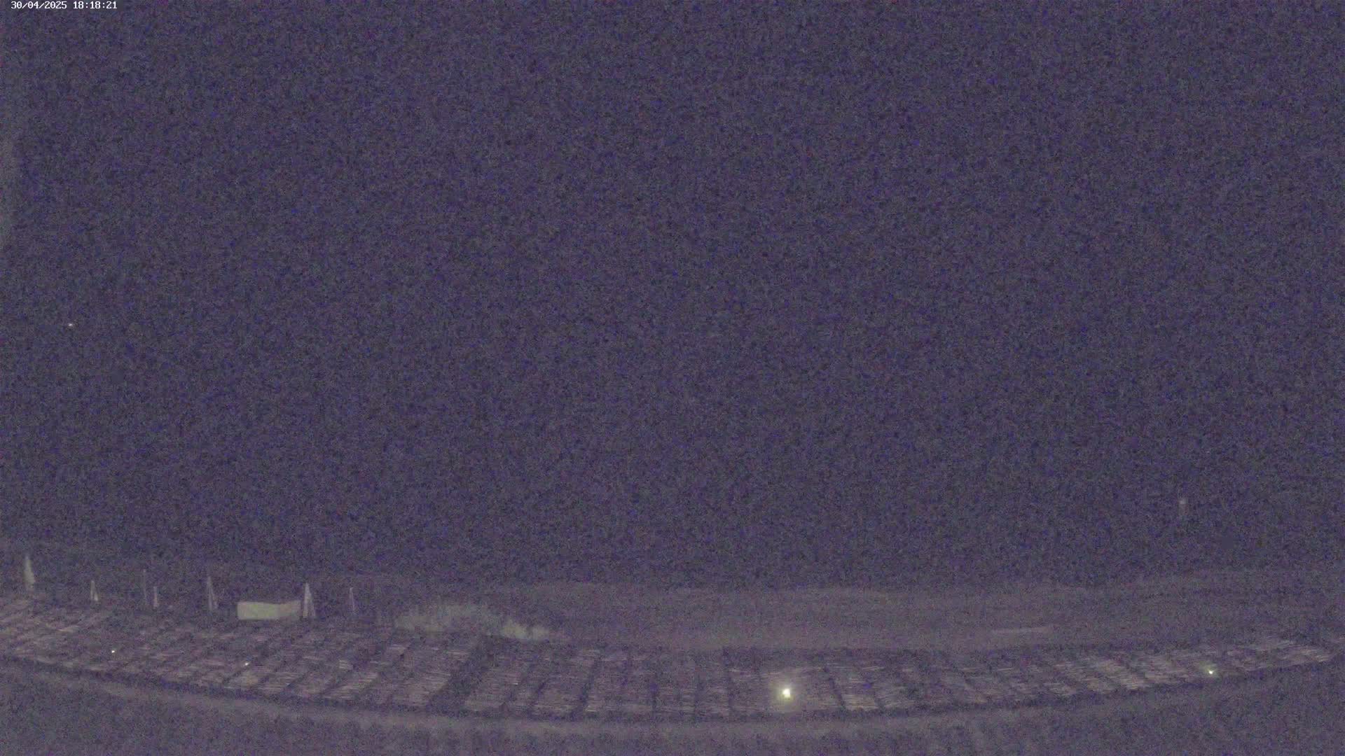 A dark, nighttime view of a large, flat, grid-like area.