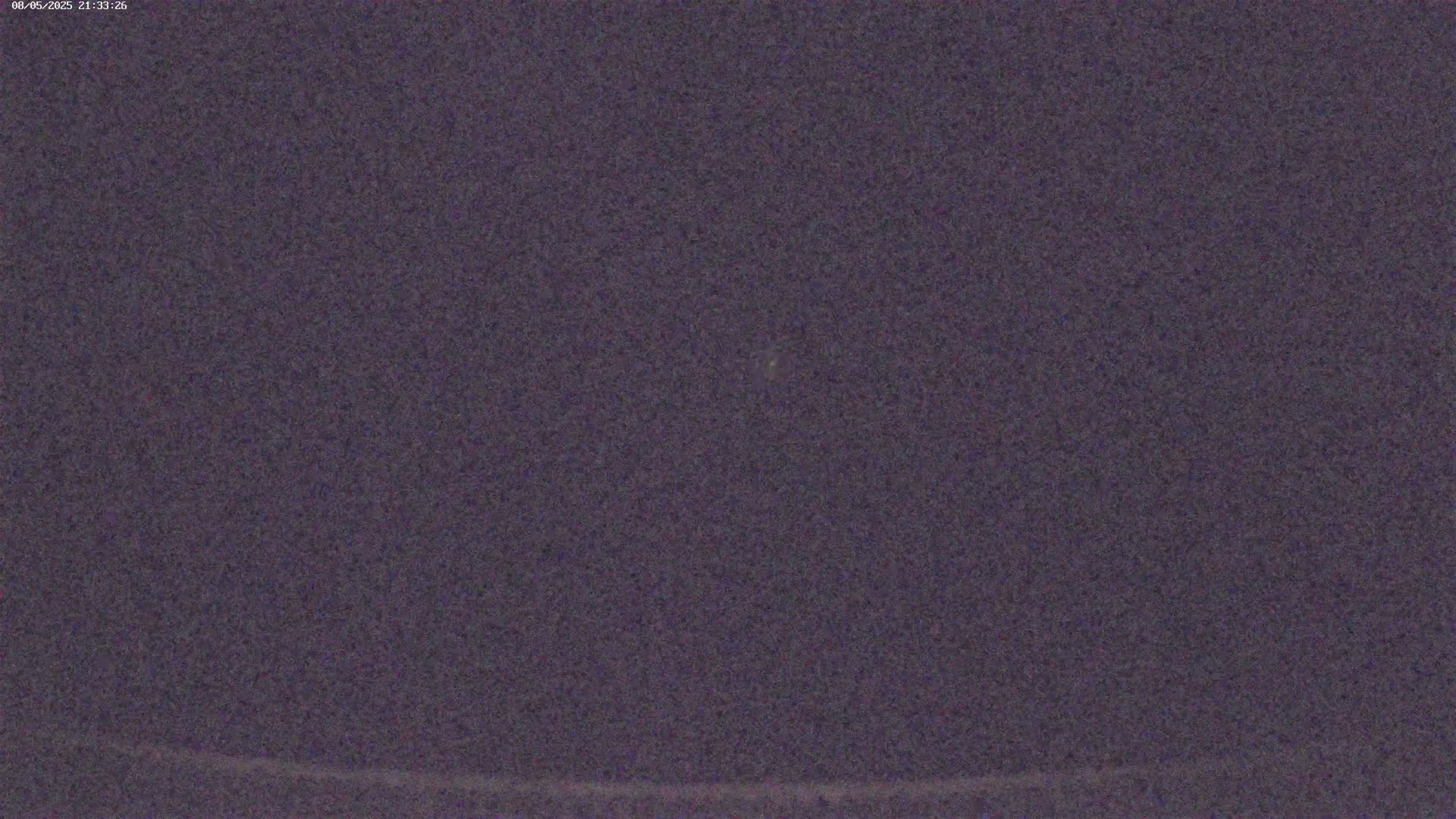 A nighttime, grainy image shows a dark purple sky.