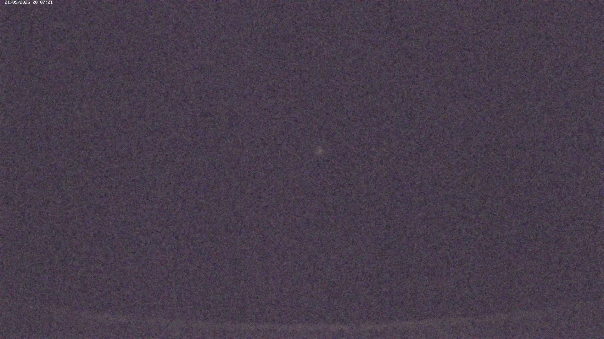 A dark purple-gray sky shows a single, faint light source.