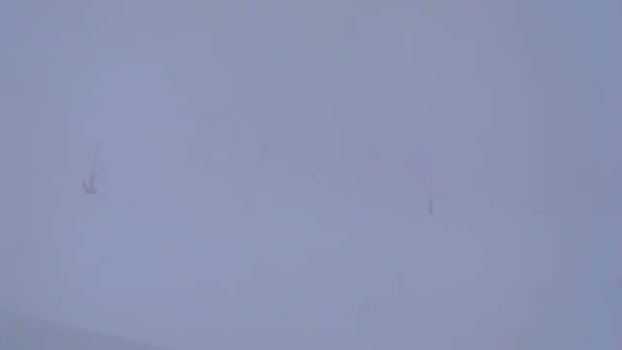 A faintly visible, possibly airborne object is seen in a heavily overcast sky.