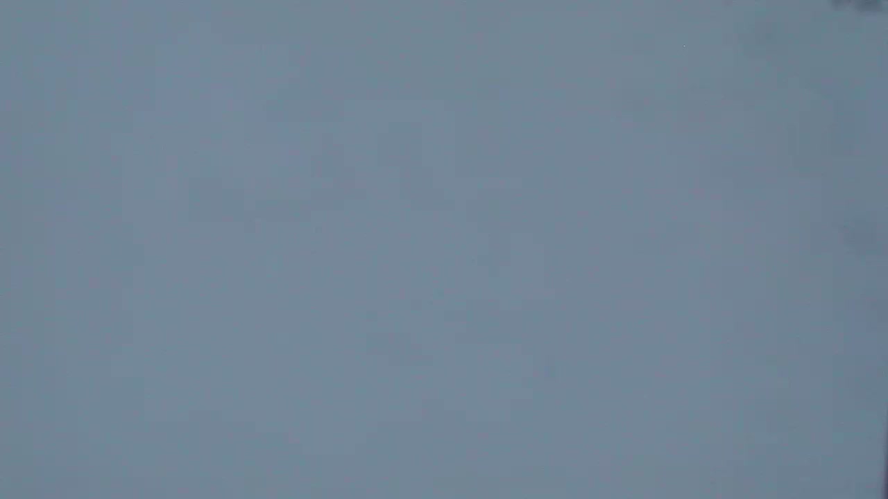 The image shows a blurry, solid, light gray background.