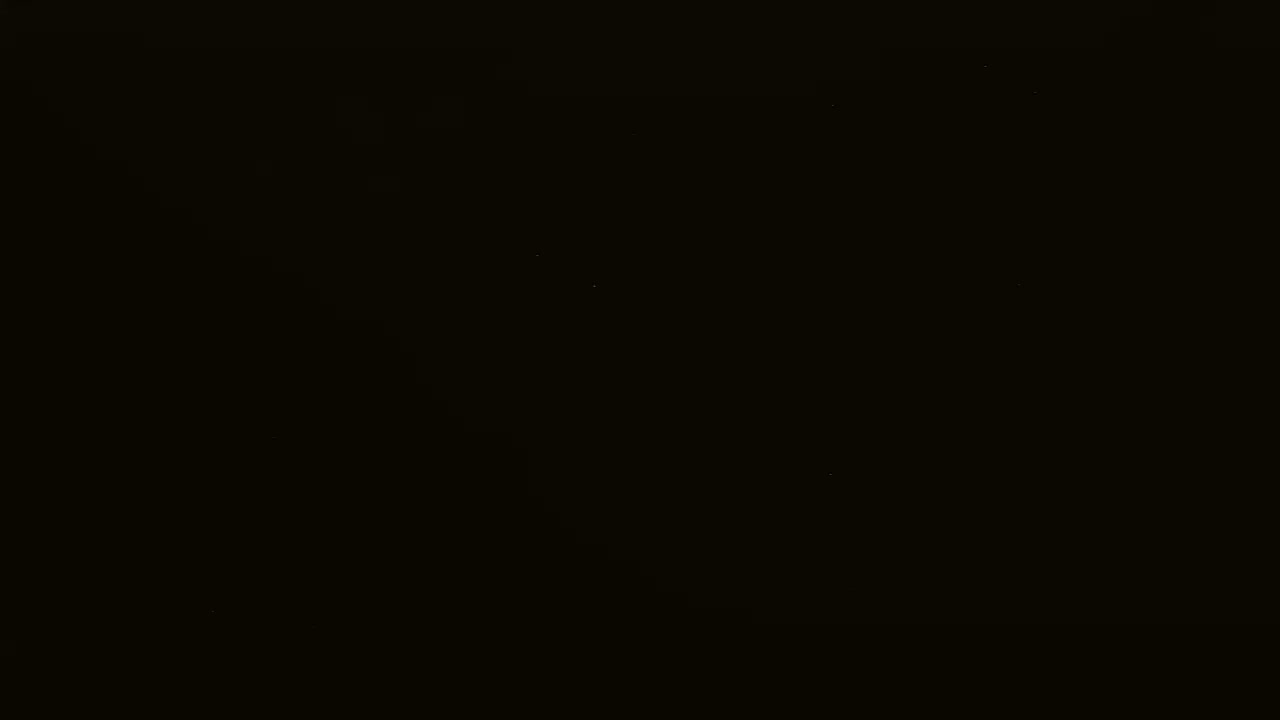 The image is almost entirely black, with a few barely visible specks of light.
