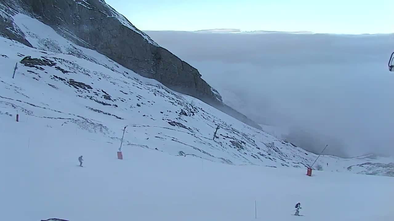 The image displays a snow-covered mountain landscape under overcast skies with very poor visibility due to heavy snowfall.