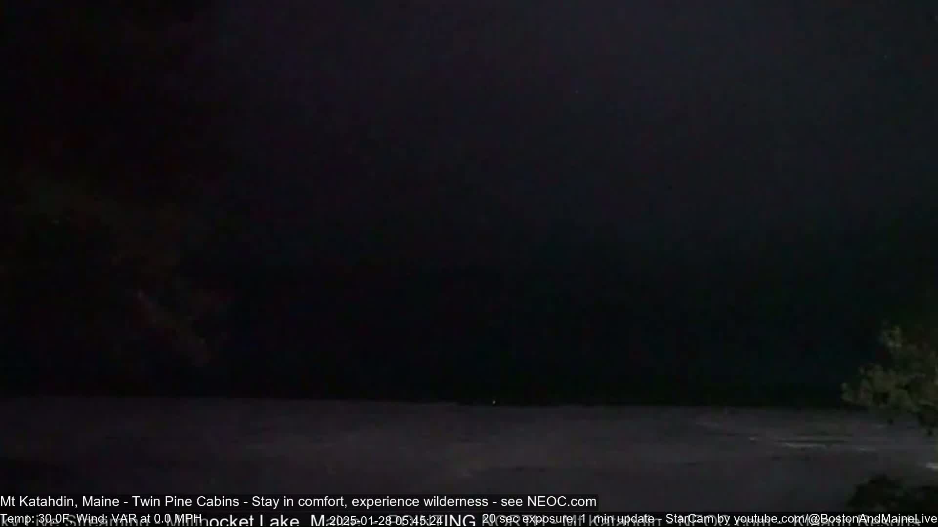 A dark, nighttime scene of a body of water under a completely overcast sky.