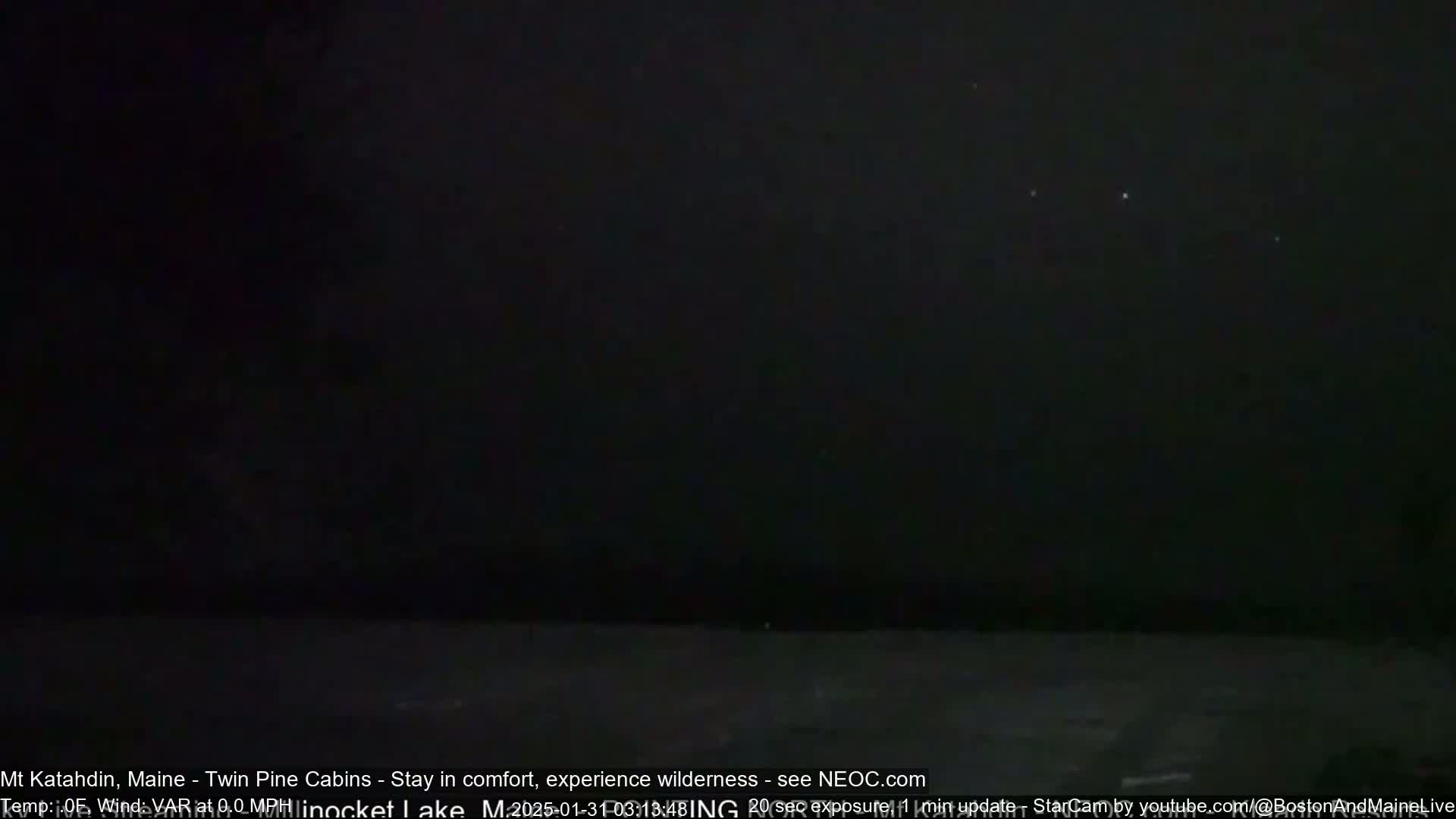 A dark, nighttime scene shows a body of water under a mostly clear sky with a few faint lights visible.