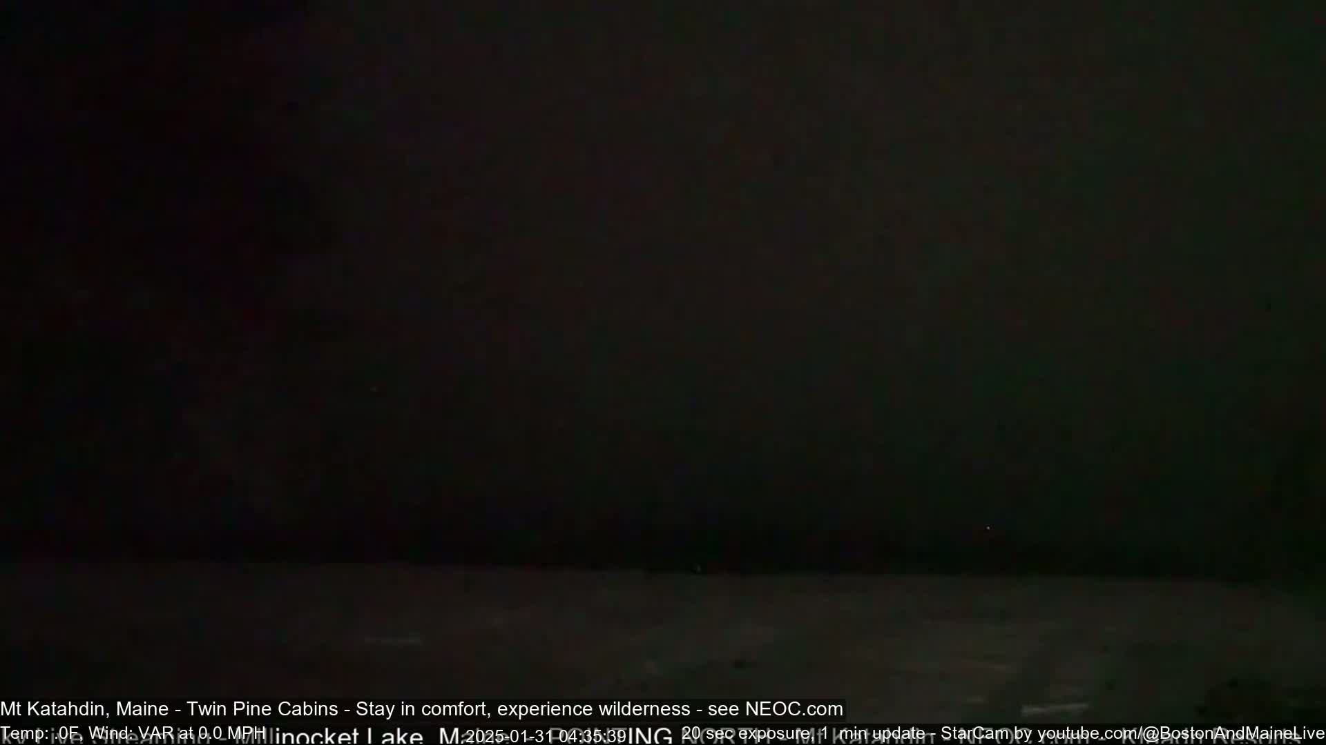 A dark, nighttime scene shows a mostly black body of water under a very dark sky.