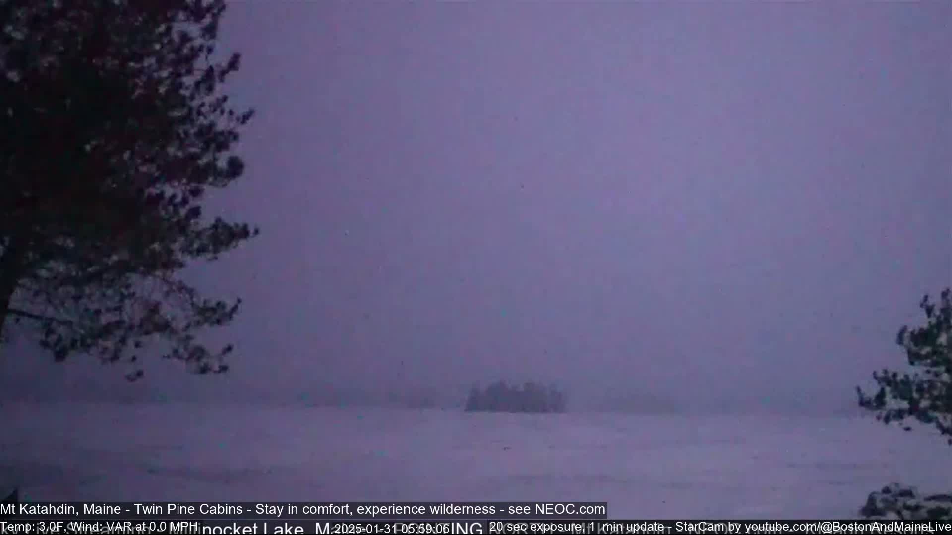 A snow-covered landscape is visible through a heavy, purplish haze under a dim sky.