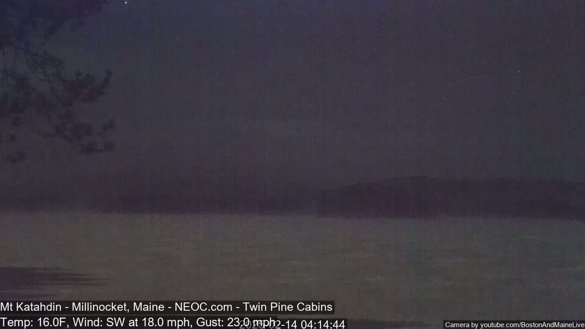 A dark, still body of water is visible under a night sky with a southwest wind blowing at 18 mph with gusts up to 23 mph.