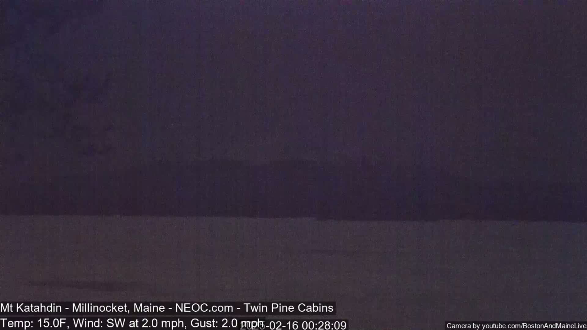 A dark, blurry, nighttime landscape is visible under a dark sky with a southwest wind of 2 mph and a temperature of 15°F.