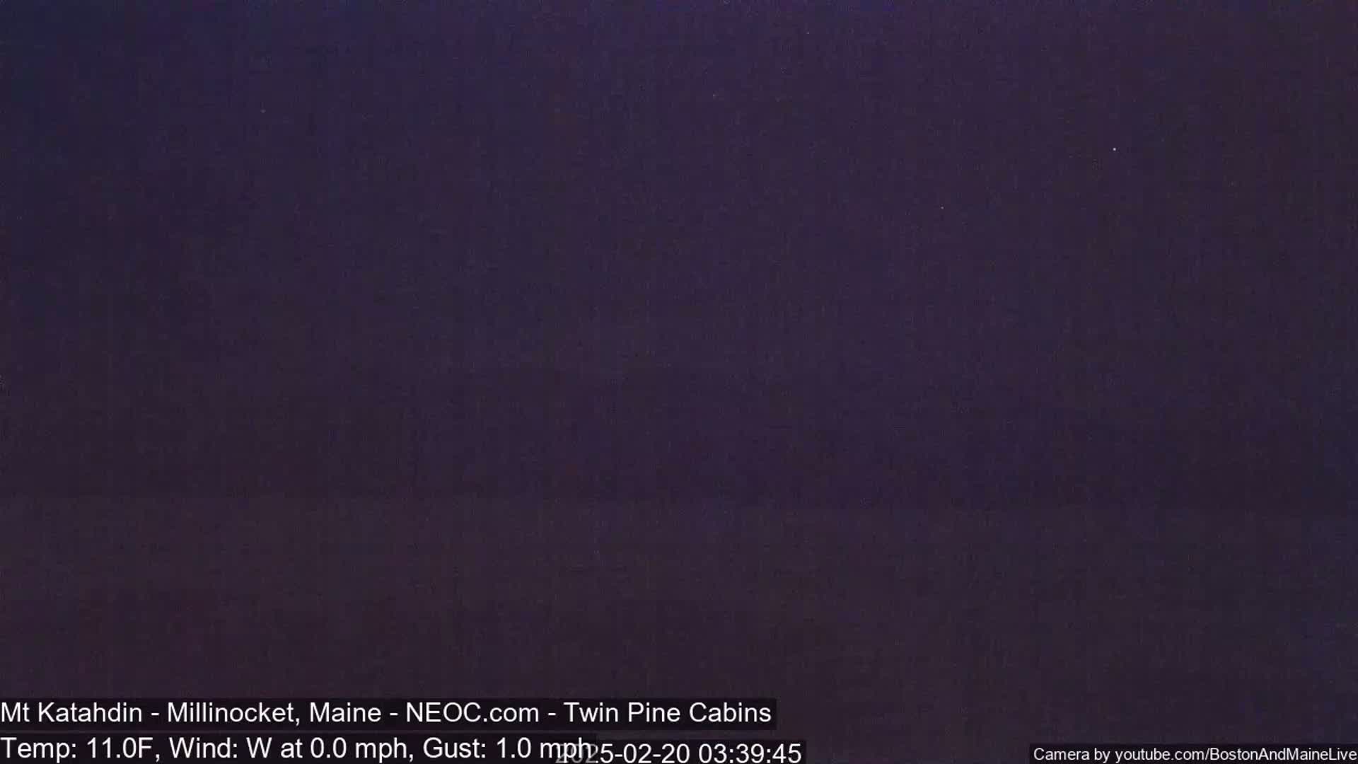 A dark, nighttime outdoor scene with a temperature of 11 degrees Fahrenheit and a calm westerly wind.