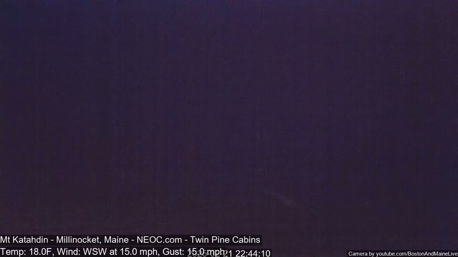 A dark, nighttime image shows a uniformly dark purple sky with a wind of 15 mph from the west-southwest and a temperature of 18°F.
