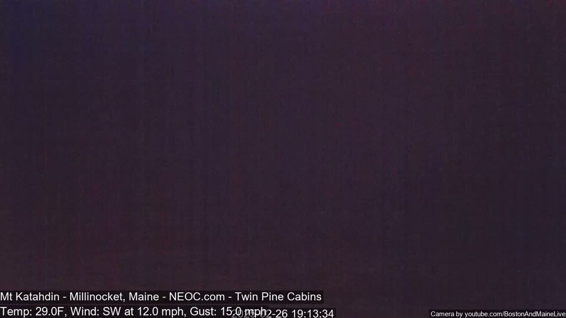 A dark, nighttime image shows a mostly uniform dark purple-gray sky with a southwest wind at 12 mph and gusts up to 15 mph.