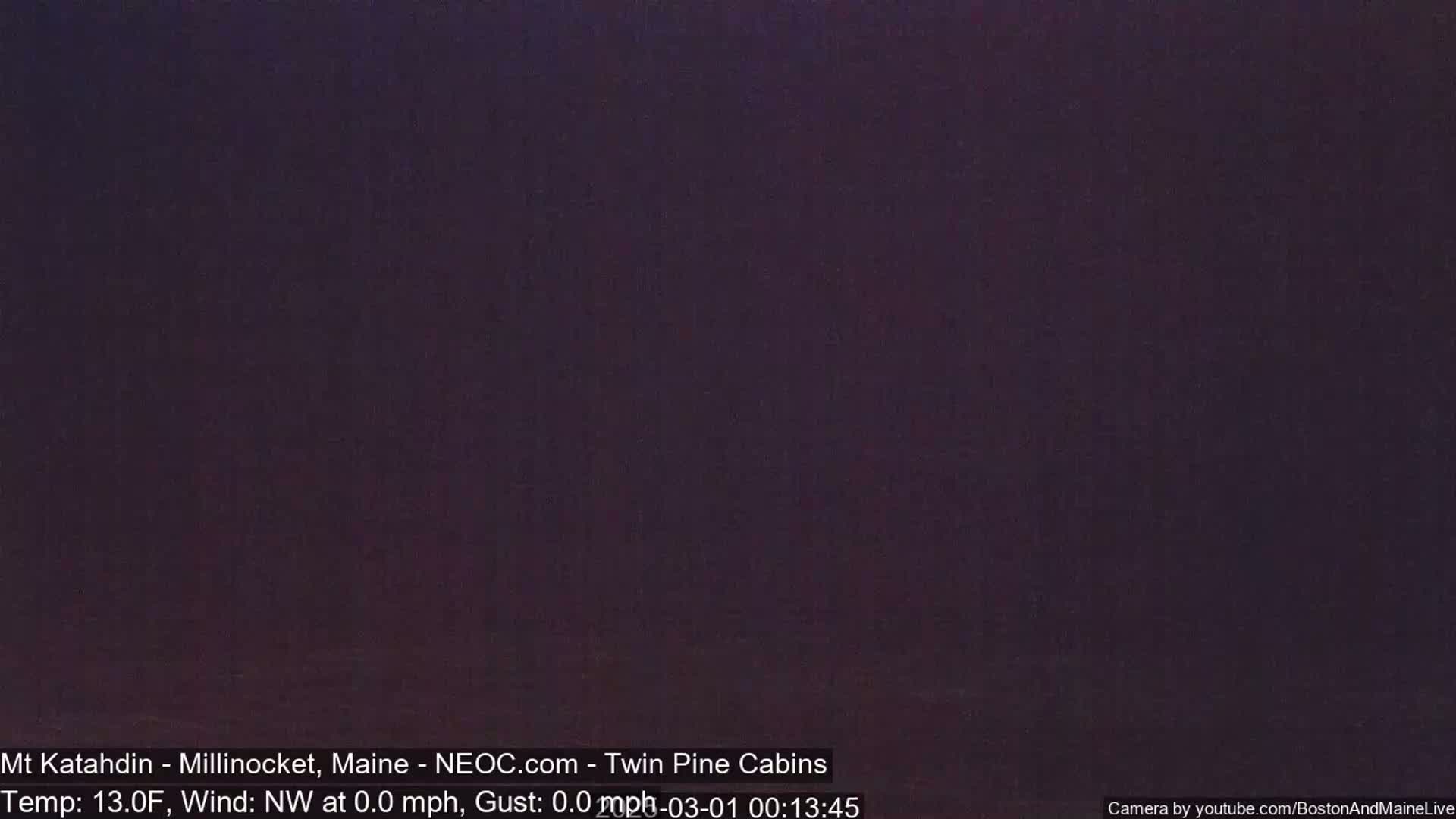 A dark, nighttime scene shows a mostly uniform, dark purple sky with calm, windless conditions.