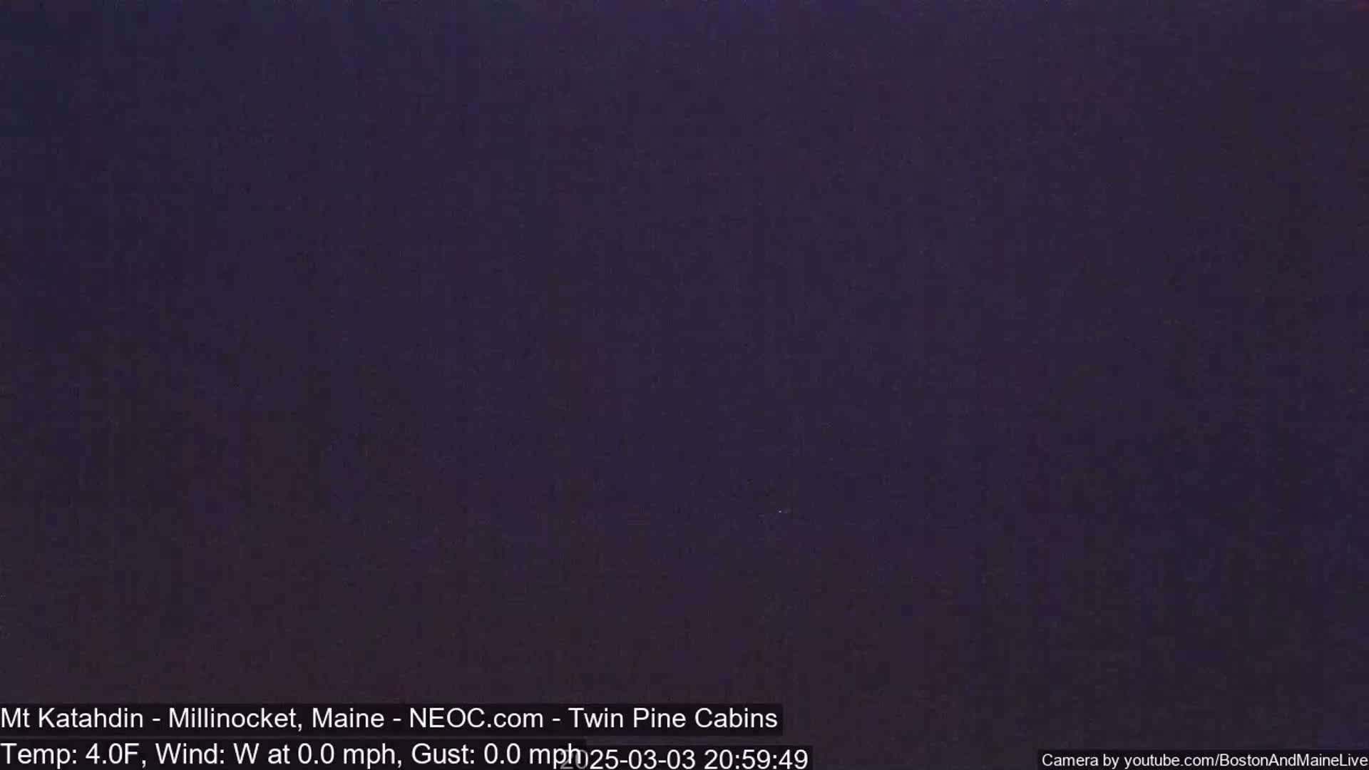A dark, nighttime image shows a uniformly dark purple-blue sky.