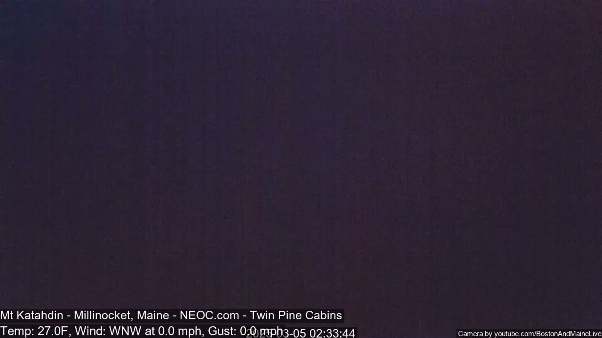 A dark, nighttime image showing a uniformly colored, dark purplish-gray sky.
