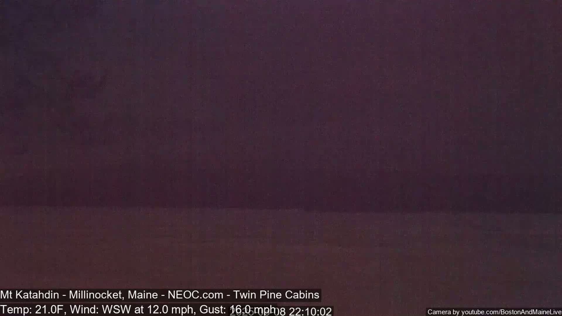 A dark, blurry image shows a mostly featureless, dark purplish landscape under a dark sky.