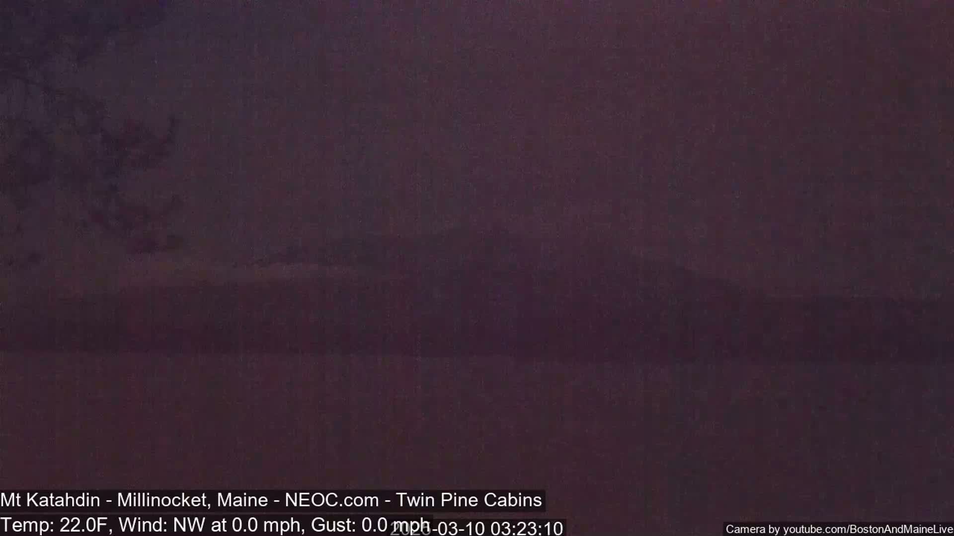A dark, blurry image shows a body of still water under a twilight sky.